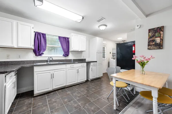 a kitchen with a white cabinets and chairs