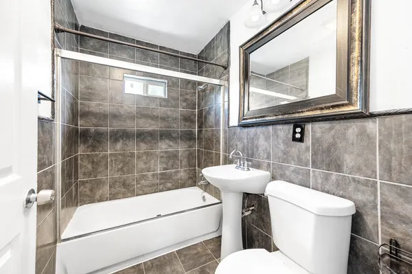 a bathroom with a toilet a sink and a glass door shower