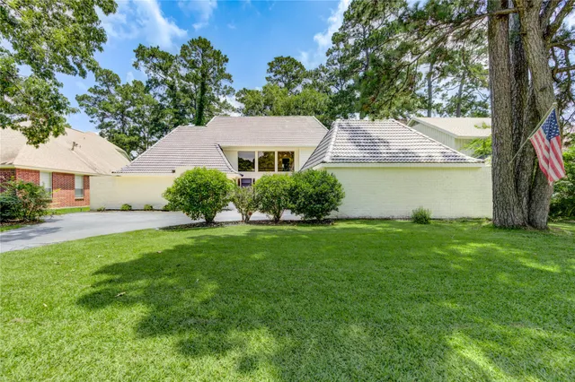 a front view of a house with a garden and plants