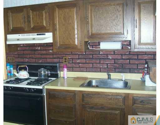 7 Lehigh Road Old Bridge, NJ 08859 - Photo 4 of 8 a kitchen with a stove a sink and a microwave