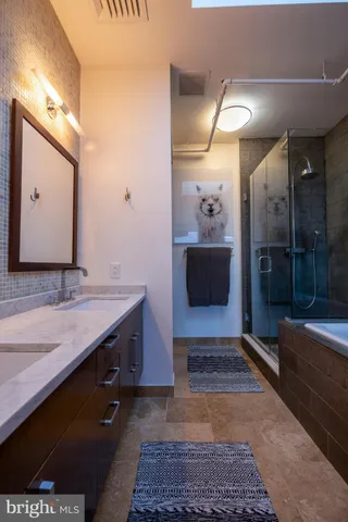 a bathroom with a sink a large mirror and a shower