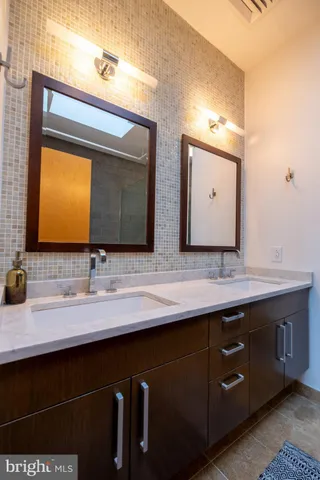a bathroom with a double vanity sink and a mirror