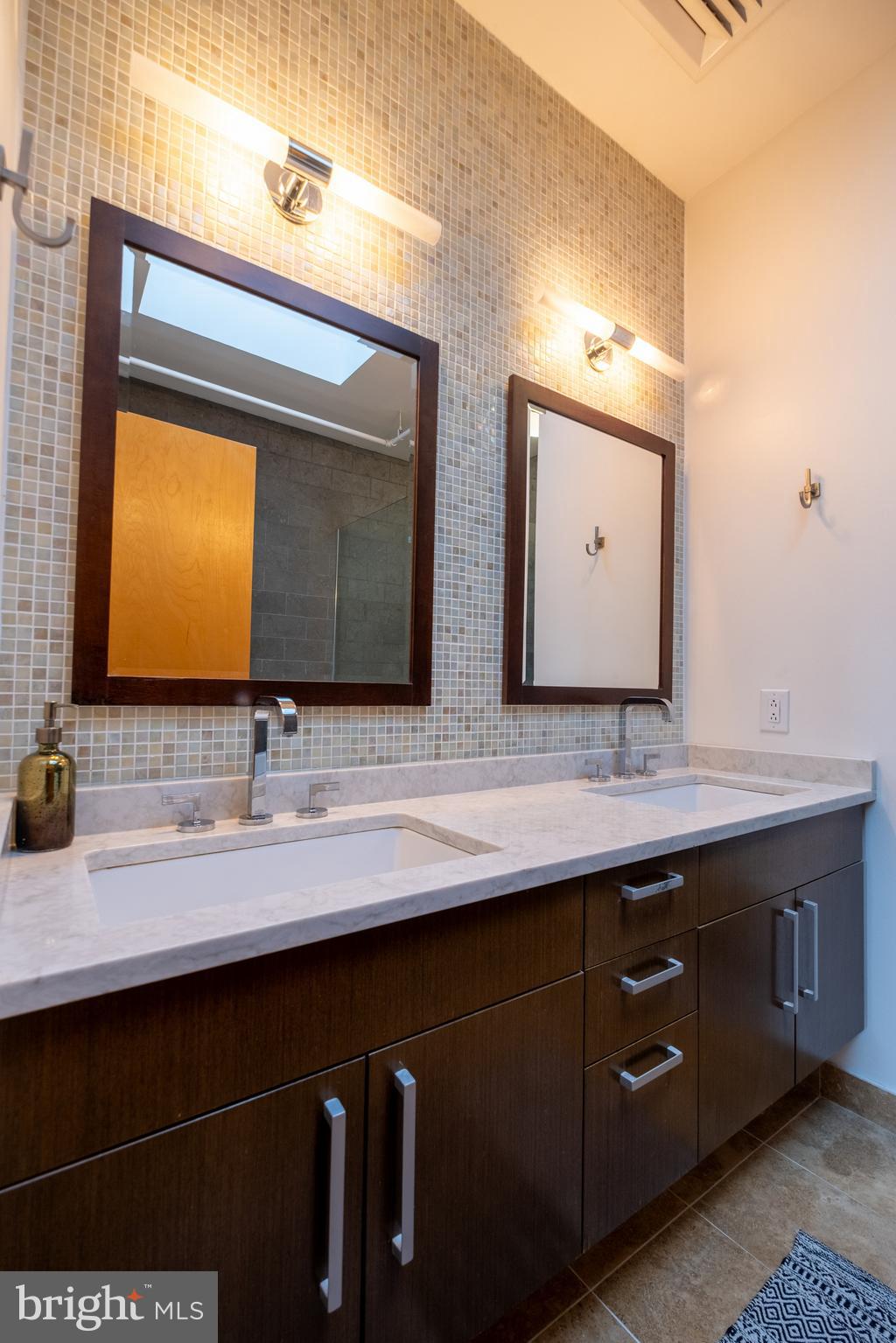 1228 Arch Street, Unit 8D Philadelphia, PA 19107 - Photo 23 of 26 a bathroom with a double vanity sink and a mirror