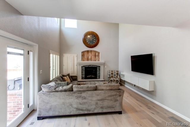 10144 Alexa Lane Highlands Ranch, CO 80130 - Photo 12 of 33 a living room with furniture a fireplace and a flat screen tv
