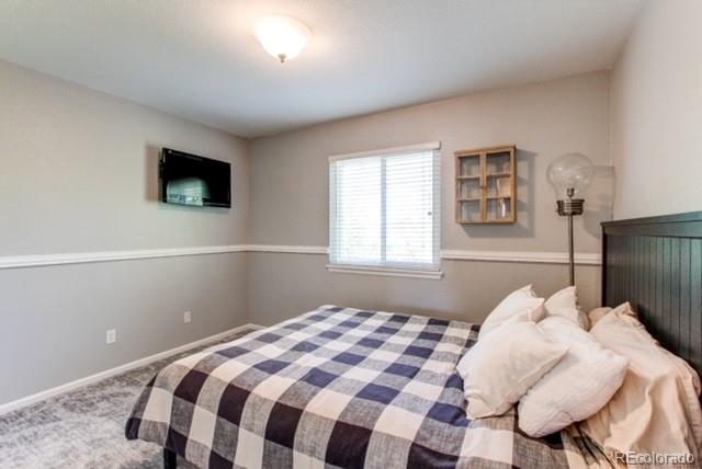10144 Alexa Lane Highlands Ranch, CO 80130 - Photo 25 of 33 a bedroom with a bed and a flat screen tv