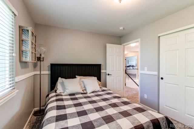 10144 Alexa Lane Highlands Ranch, CO 80130 - Photo 26 of 33 a bedroom with a bed and wooden floor