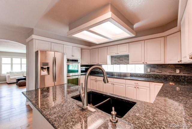 10144 Alexa Lane Highlands Ranch, CO 80130 - Photo 10 of 33 a kitchen with granite countertop a sink a stove and refrigerator