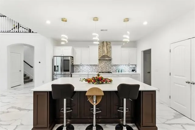 a kitchen with refrigerator cabinets dining table and chairs