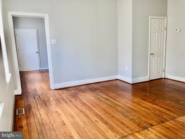 a view of a room with wooden floor and bench