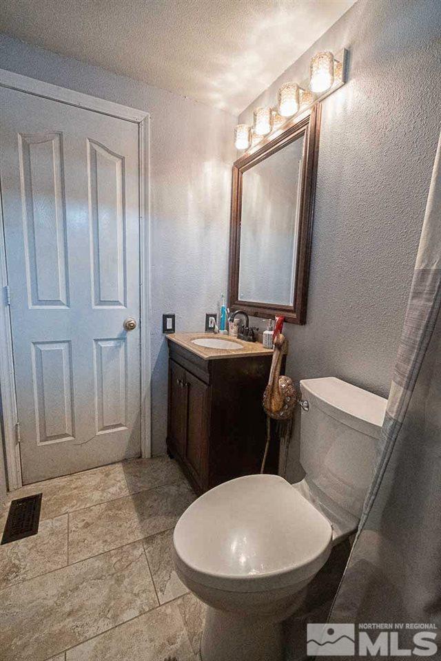 2745 Snapdragon Way Reno, NV 89512 - Photo 17 of 30 a bathroom with a sink toilet and mirror
