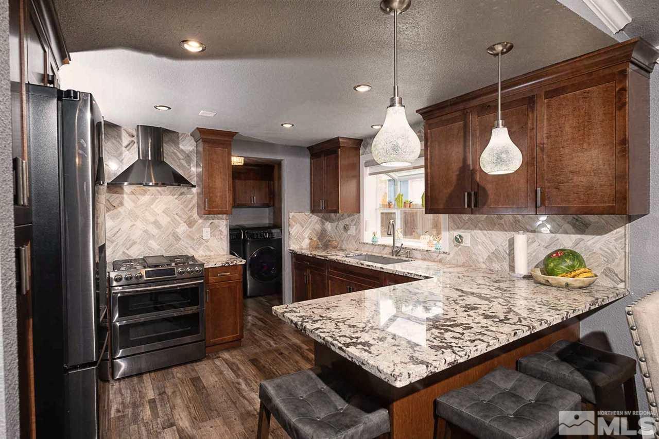 2745 Snapdragon Way Reno, NV 89512 - Photo 6 of 30 a kitchen with granite countertop a stove a oven and a refrigerator
