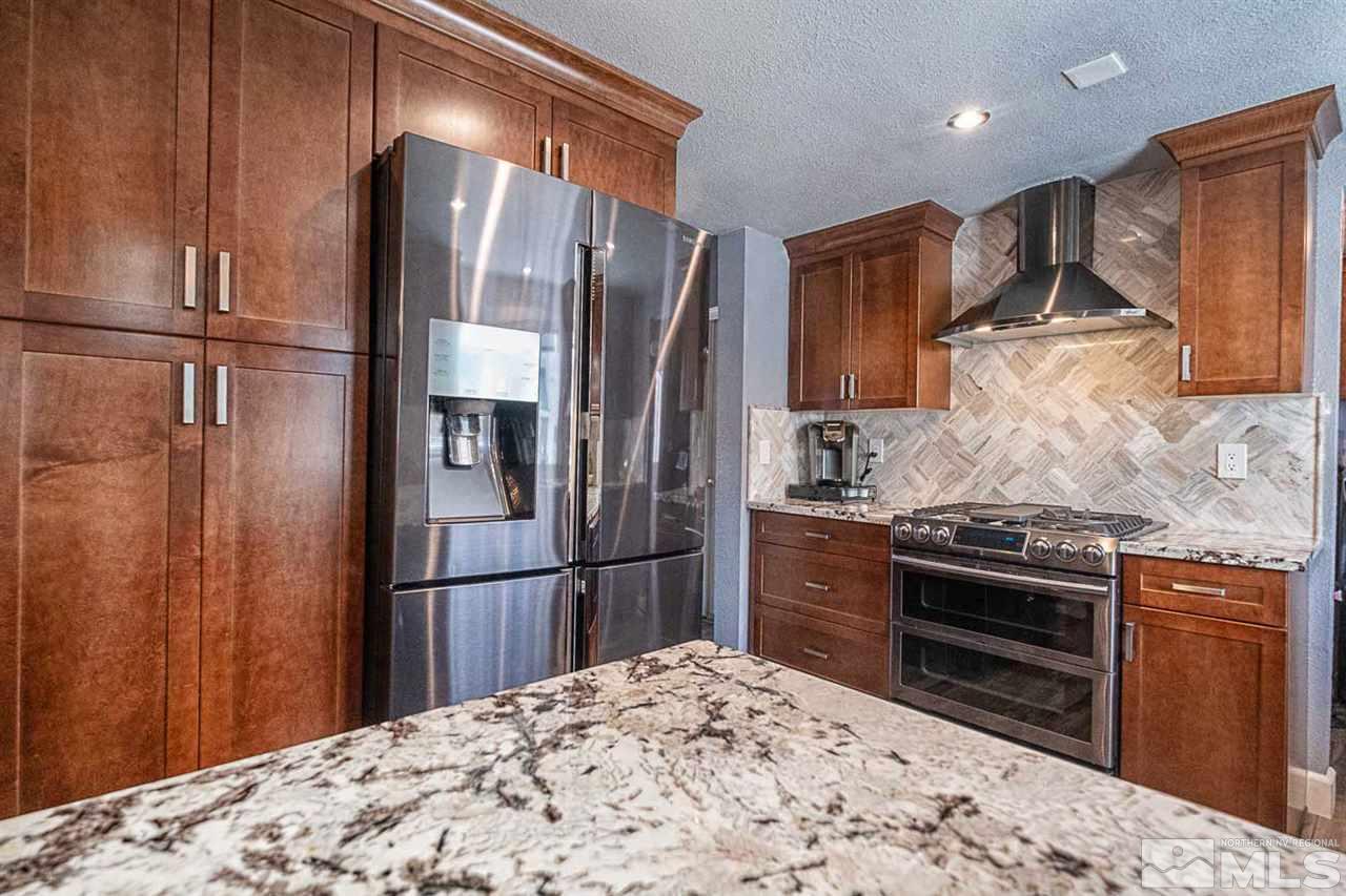 2745 Snapdragon Way Reno, NV 89512 - Photo 7 of 30 a kitchen with granite countertop a refrigerator and a sink