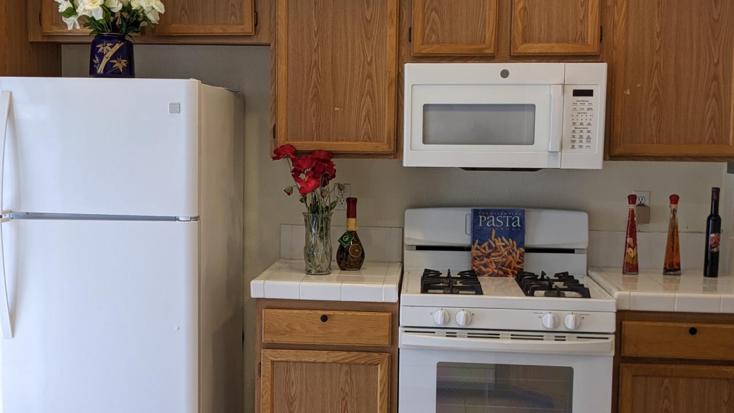 5691 Spry Common Fremont, CA 94538 - Photo 10 of 20 a kitchen with a stove and white cabinets