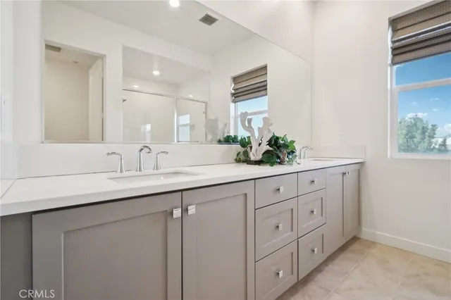 a bathroom with double sink and a mirror