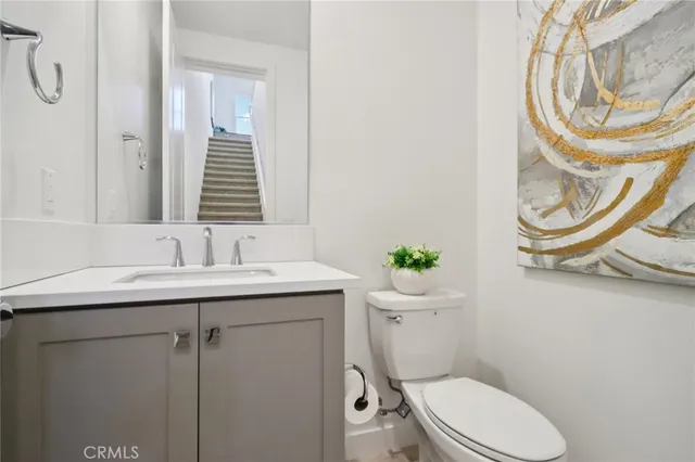 a bathroom with a granite countertop toilet sink and mirror