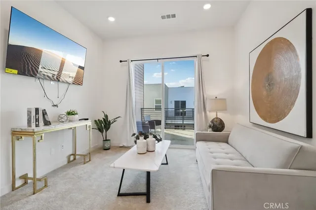 a living room with furniture a mirror and entryway