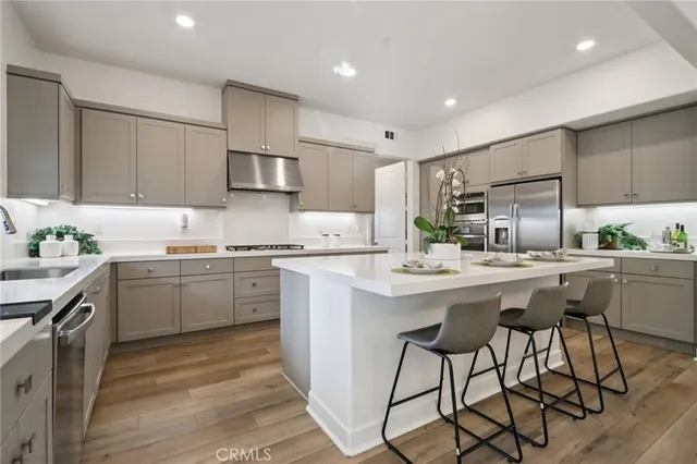 a kitchen with a sink a counter top space stainless steel appliances and cabinets