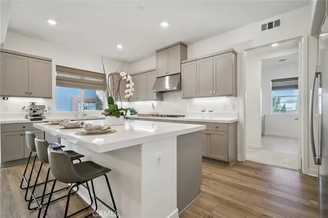 a kitchen with a sink a center island stainless steel appliances and cabinets
