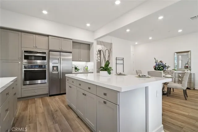 a kitchen with stainless steel appliances kitchen island granite countertop a refrigerator and a stove top oven
