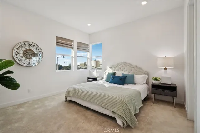 a bedroom with a bed and a lamp on dresser