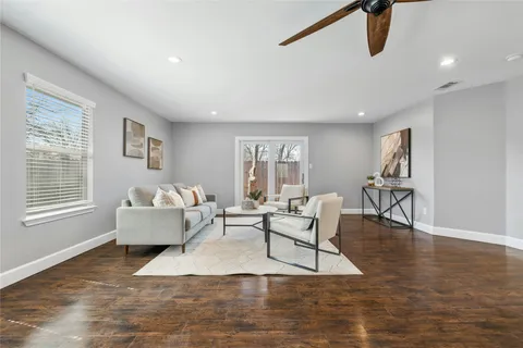a living room with furniture and a wooden floor