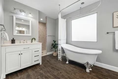 a spacious bathroom with a double vanity sink a mirror and a bathtub