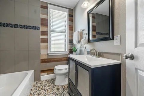 a bathroom with a sink toilet a mirror and bathtub