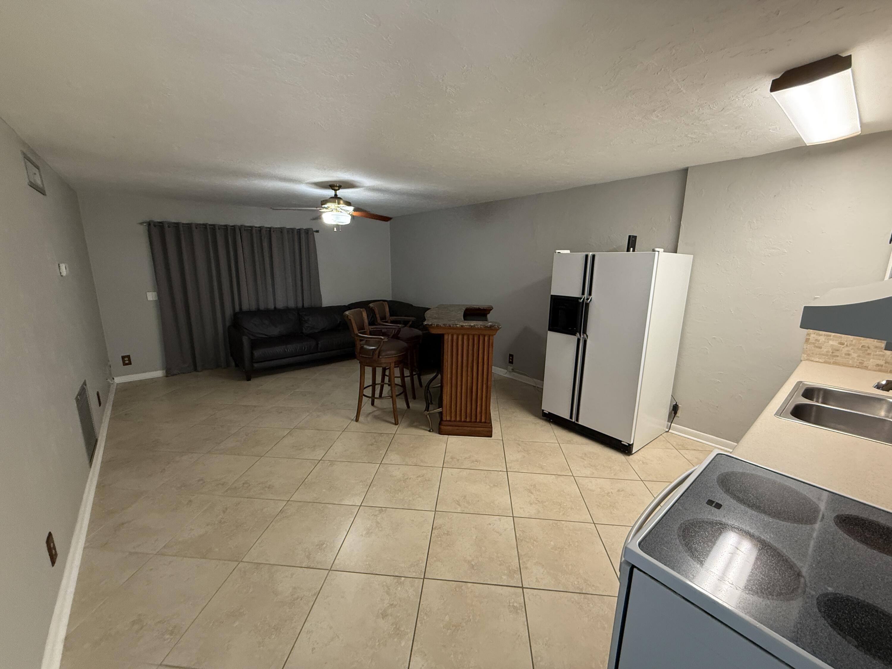 125 Mayfield Road, Unit B Lantana, FL 33462 - Photo 2 of 8 a kitchen with furniture and a refrigerator