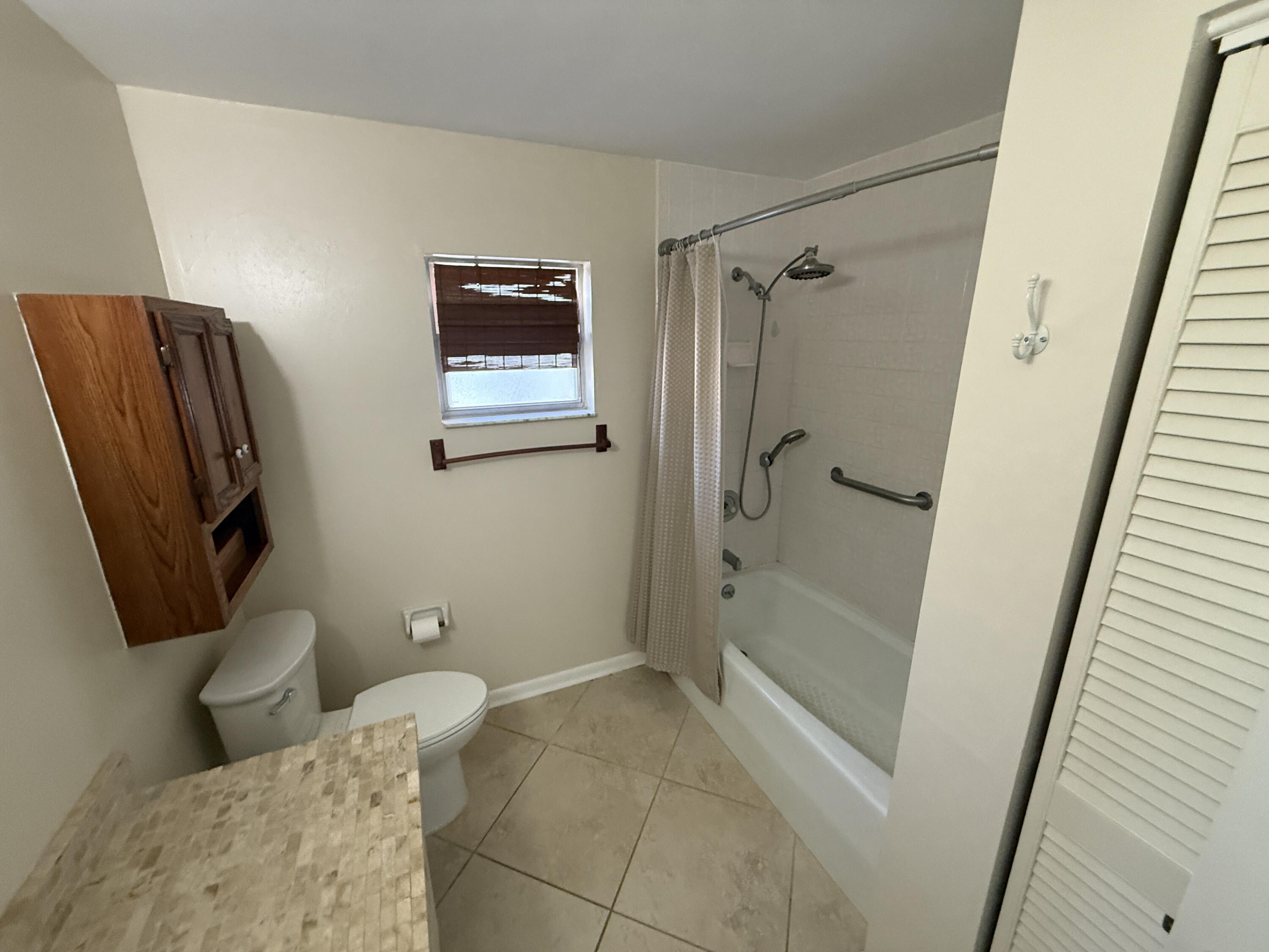125 Mayfield Road, Unit B Lantana, FL 33462 - Photo 6 of 8 a bathroom with a shower and a toilet