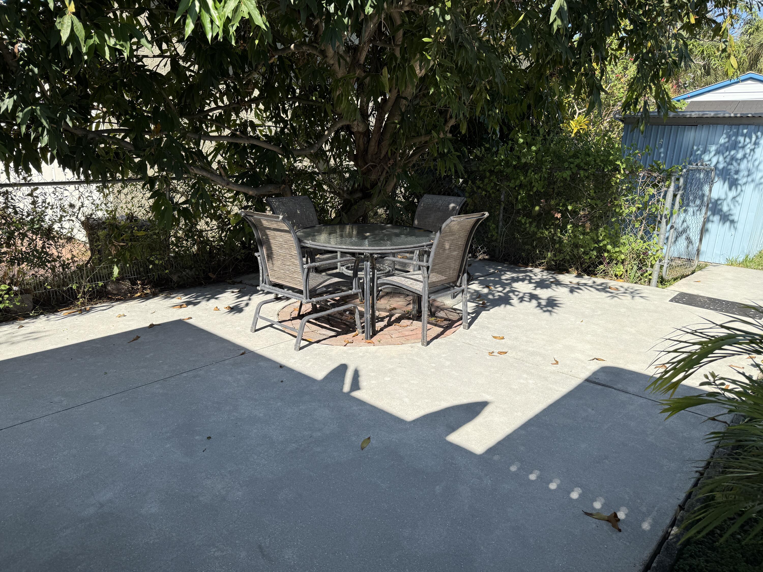 125 Mayfield Road, Unit B Lantana, FL 33462 - Photo 8 of 8 a view of backyard with a table and chairs and wooden fence