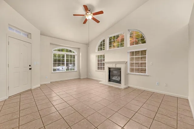 a view of an empty room with a fireplace and a window