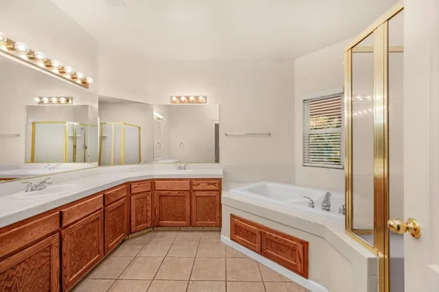 a bathroom with a granite countertop sink and a bathtub