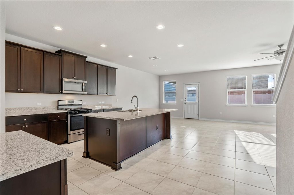 10909 Mickelson Drive Austin, TX 78747 - Photo 4 of 23 a large kitchen with stainless steel appliances granite countertop a stove sink and cabinets
