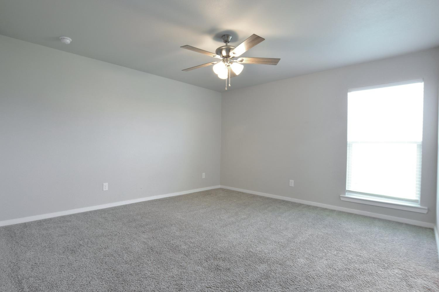 7513 28th Street Lubbock, TX 79407 - Photo 11 of 18 an empty room with a window and a fan