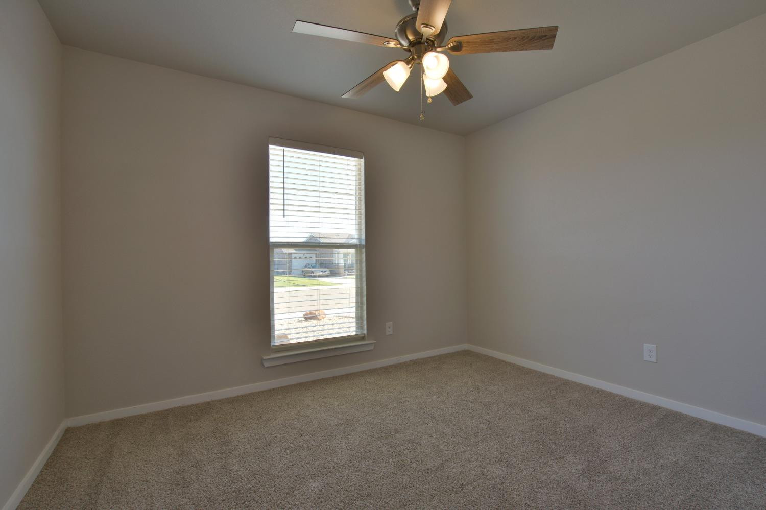 7513 28th Street Lubbock, TX 79407 - Photo 15 of 18 an empty room with a window and a fan