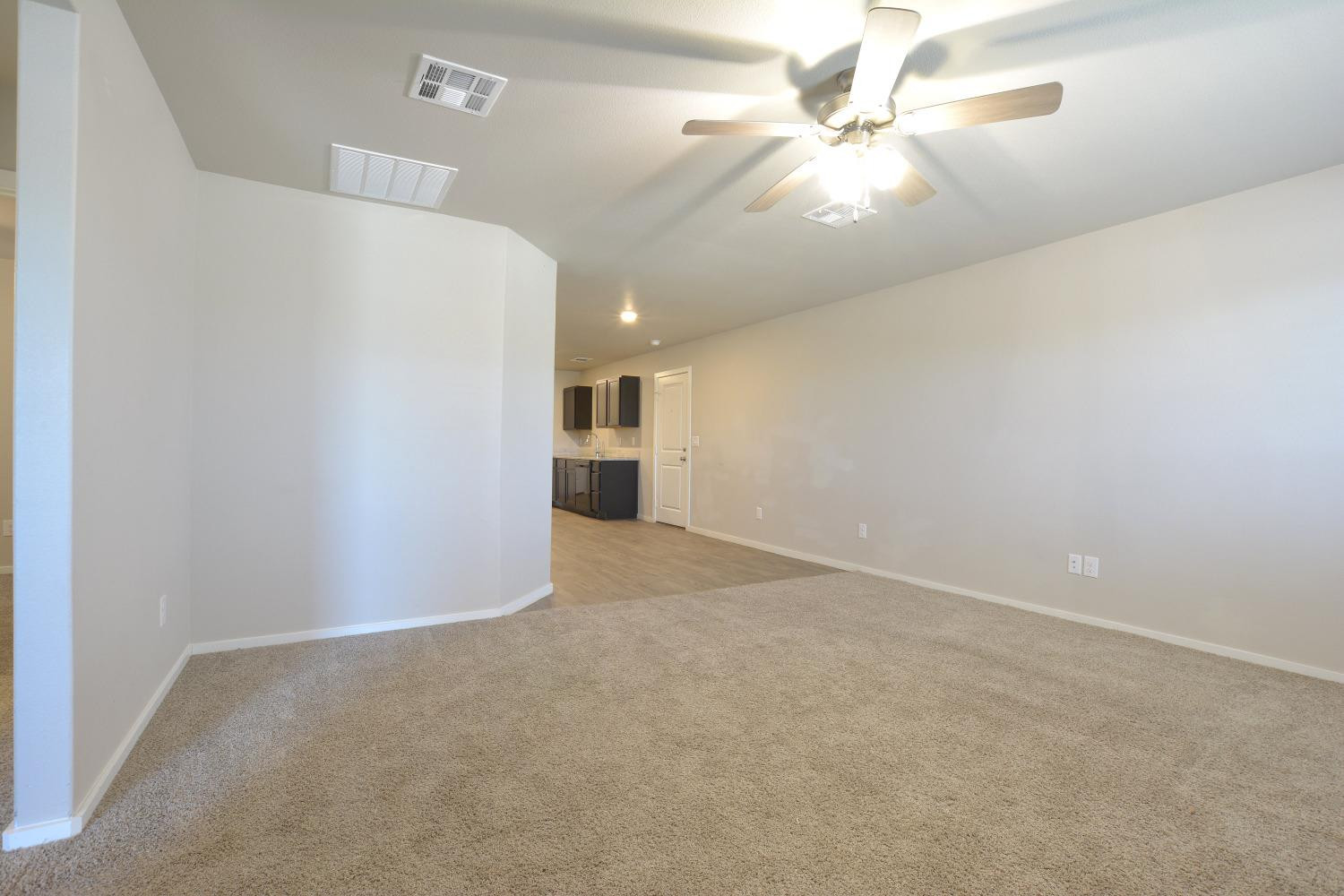 7513 28th Street Lubbock, TX 79407 - Photo 4 of 18 en empty room with windows and ceiling fan