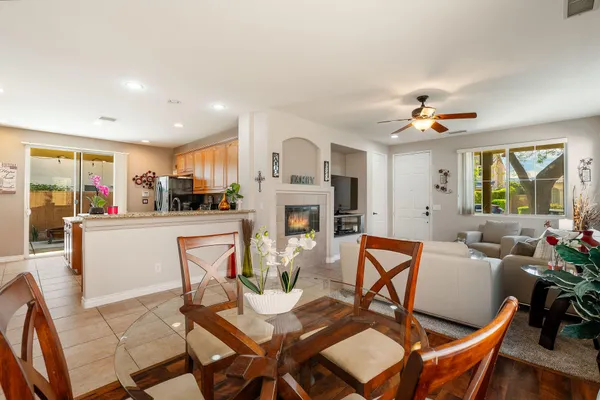 a living room with fireplace furniture and a view of kitchen