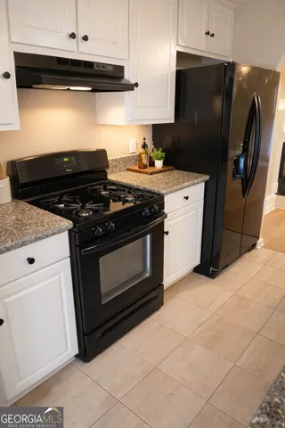 a kitchen with stainless steel appliances granite countertop a stove and a refrigerator
