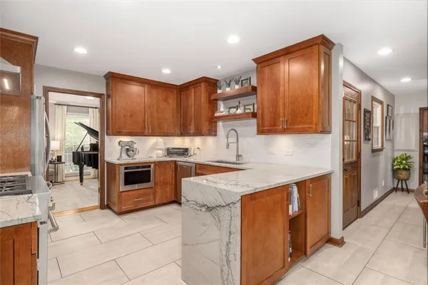 a kitchen with granite countertop a sink and refrigerator