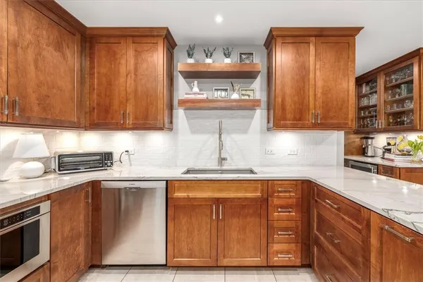 a kitchen with granite countertop wooden cabinets stainless steel appliances and a sink