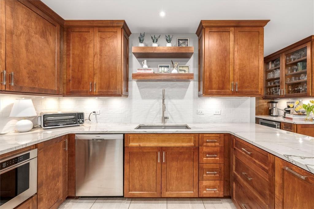 2282 Marthasville Court Smoke Rise, GA 30087 - Photo 13 of 48 a kitchen with granite countertop wooden cabinets stainless steel appliances and a sink
