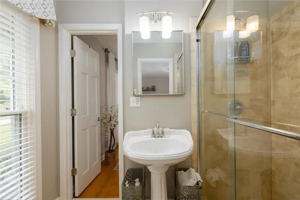 a bathroom with a sink a mirror and shower