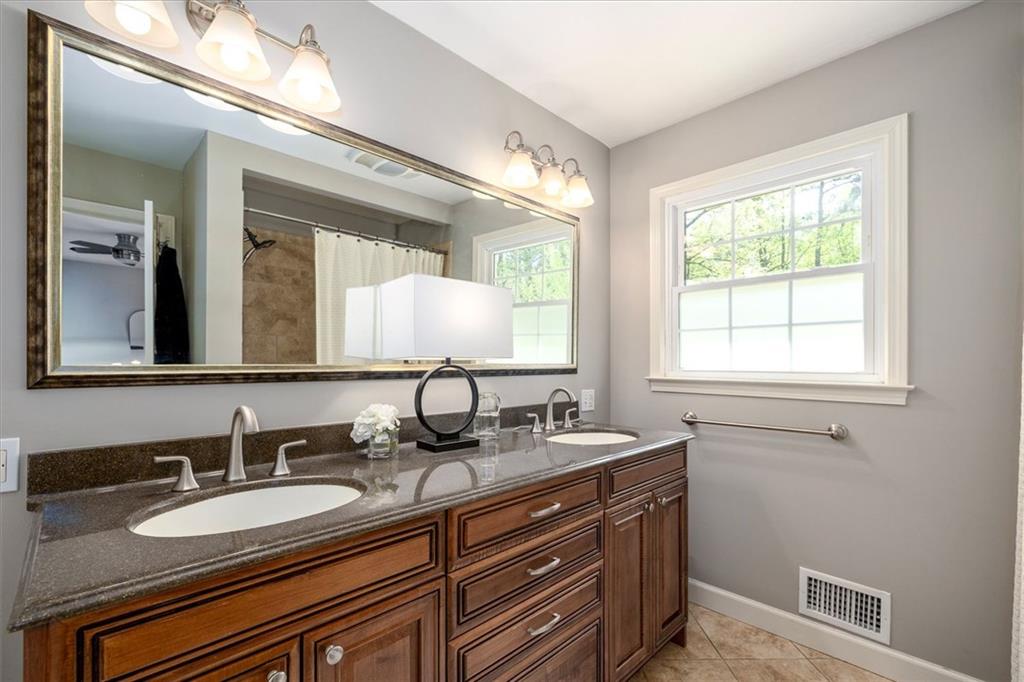 2282 Marthasville Court Smoke Rise, GA 30087 - Photo 26 of 48 a bathroom with a double vanity sink and a mirror