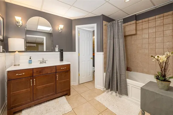 a bathroom with a tub shower vanity and a sink