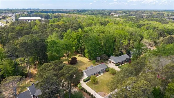an aerial view of residential houses with outdoor space and trees
