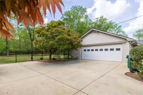 a view of a house with a yard and large trees