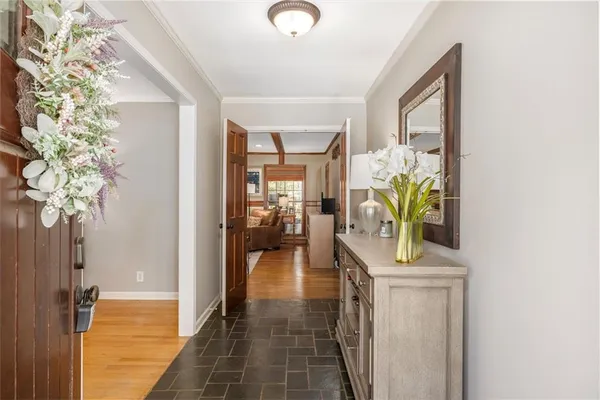 a hallway with painting and a potted plant