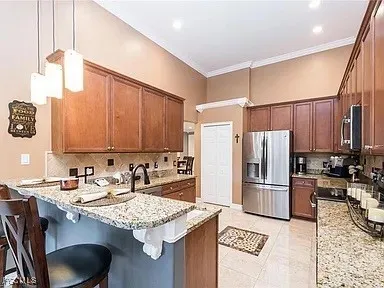 a kitchen with stainless steel appliances granite countertop a sink refrigerator and cabinets