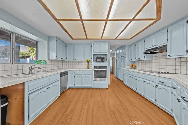 a kitchen with stainless steel appliances granite countertop a stove sink and cabinets