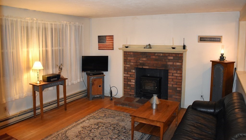 1702 State Road Plymouth, MA 02360 - Photo 3 of 17 a living room with furniture a flat screen tv and a fireplace